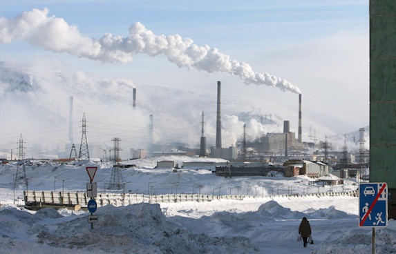 A woman walks near a nickel mine in the arctic city of Norilsk